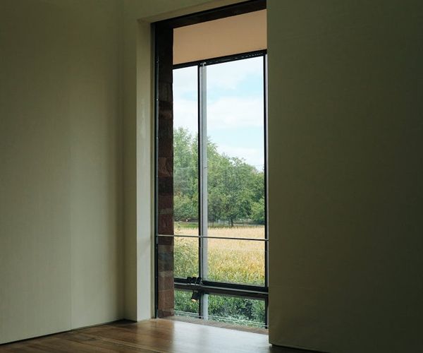 Spacious, empty fitness studio with wooden floors and large windows.