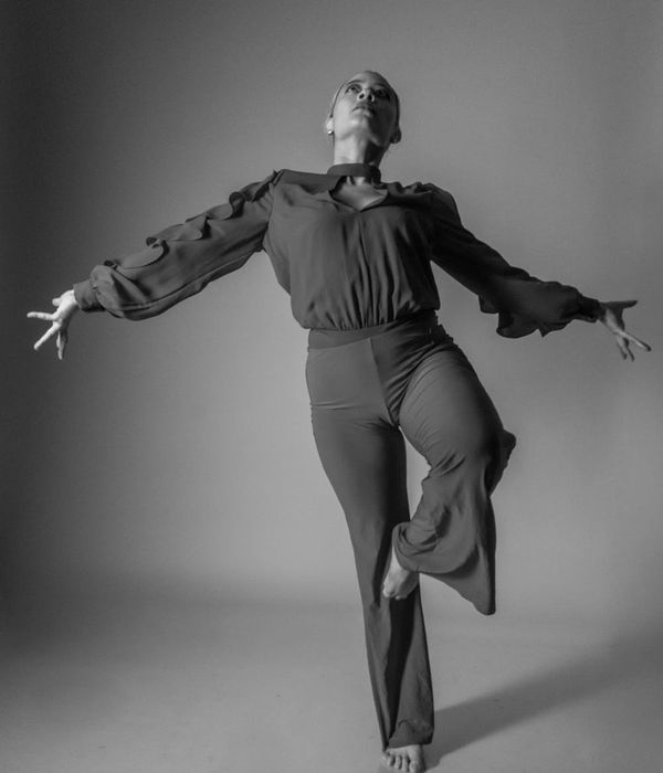 Woman performing a fluid cardio movement in a minimalist studio.